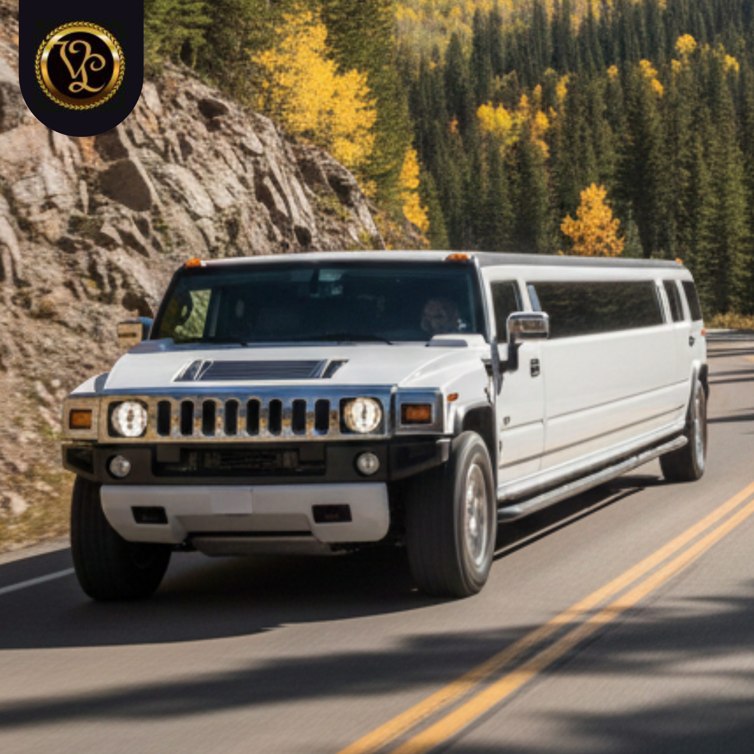 White Hummer stretch limo driving on a scenic mountain road for AAA VIP Limo.